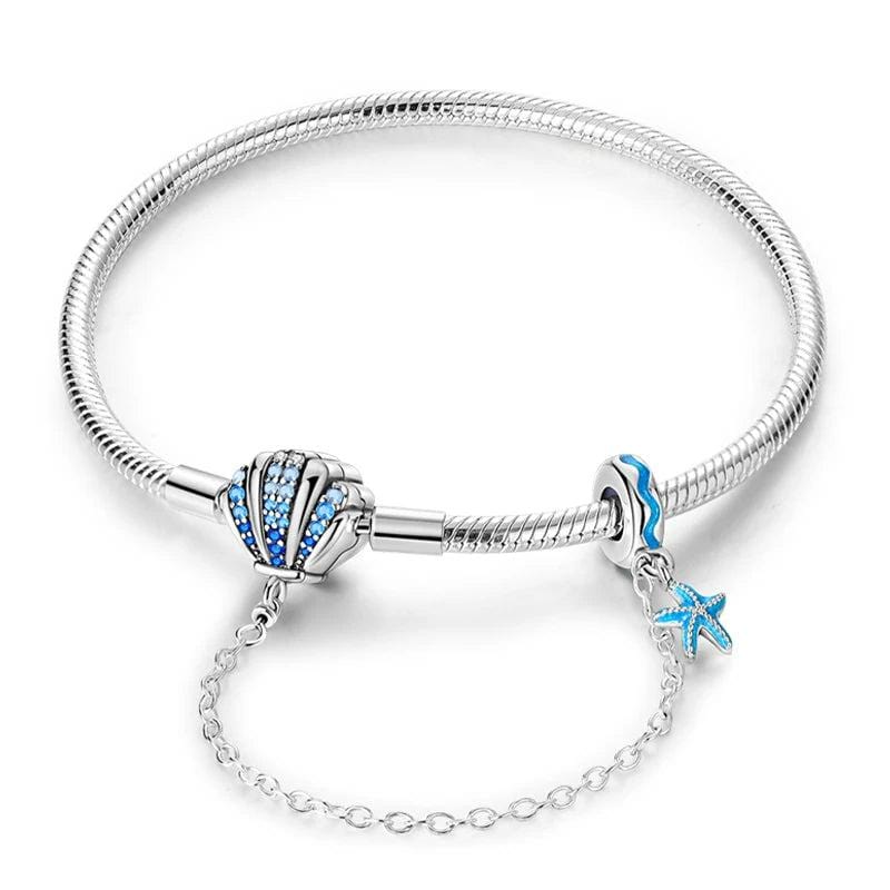 Pulsera con temática oceánica y dijes de conchas marinas y estrellas de mar de cristal azul