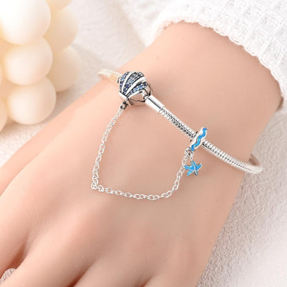 Pulsera con temática oceánica y dijes de conchas marinas y estrellas de mar de cristal azul