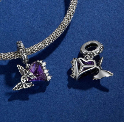 Dije colgante con forma de calavera y mariposa sobre corazón morado